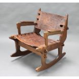 Angel Pazmino, a 1960's hardwood and embossed leather rocking chair with aztec designs to the