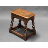 A rectangular carved oak joined stool with arcaded decoration, raised on spiral turned and block