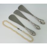 A string of cultured pearls and 3 silver handled shoe horns