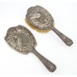 An Edwardian repousse silver hair brush and hand mirror decorated with birds and insects