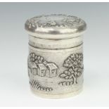 An engine repousse silver circular lidded box decorated with figures in a village setting 9cm, 232