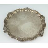 A Georgian style silver salver with shell and scroll rim enclosed by scrolling flowers on scroll
