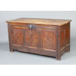 A 17th/18th Century carved oak coffer of panelled construction with hinged lid, the interior