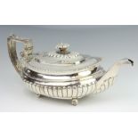 A George IV oblong repousse silver demi-fluted teapot raised on ball feet with chased crest,