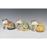 Three Rye Cinque Port Pottery figures of reclining cats with glass eyes, decorated with flowers 11cm