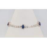 An 18ct white gold sapphire and diamond cluster bracelet, diamonds 5ct, sapphires 5ct, 18cm