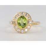 An 18ct yellow gold peridot and diamond cluster ring, the centre oval stone approx. 1.3ct surrounded