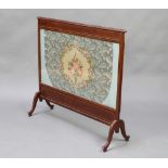 An Edwardian rectangular inlaid mahogany fire screen with Berlin woolwork panel, raised on