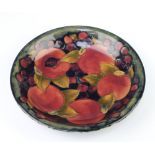 A Walter Moorcroft shallow dish decorated with the pomegranate design, base with impressed signature