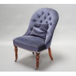 An Early Victorian nursing chair upholstered in blue buttoned material, raised on turned and