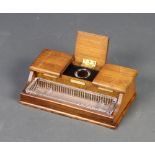 An Edwardian oak 3 division ink stand with hinged lid revealing 3 associated inkwells and having a