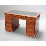 An Edwardian walnut desk with inset green leather writing surface above 1 long and 8 short drawers