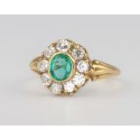 An 18ct yellow gold oval emerald and diamond cluster ring, the centre stone approx. 0.8ct surrounded