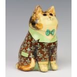 A Rye Pottery Joan and David De Bethel cat with glass eyes, decorated with a flowery frock coat,