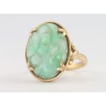 A 14ct yellow gold carved jade ring, 5.8 grams, size M