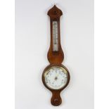 A Victorian aneroid barometer and thermometer with enamelled dial, contained in a walnut wheel case