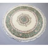 A circular white and green floral patterned Indian rug 178cm diam. Slight staining to the tassles