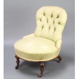 A Victorian nursing chair upholstered in green buttoned material raised on turned and fluted