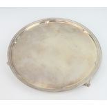 A circular silver salver with beaded rim and engraved monogram on scroll feet, Sheffield 1928,