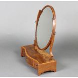 A Sheraton style oval plate dressing table mirror contained in a mahogany frame and raised on