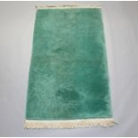 A green ground sculpted Chinese rug with bamboo decoration 221cm x 125cm Stained