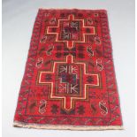 A red and blue ground Belouche rug with 2 stylised medallions to the centre 156cm x 87cm