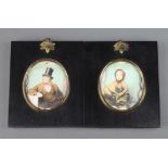 A pair of oval coloured prints of a seated lady and gentleman in ebonised and gilt mounted frames