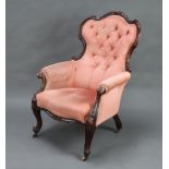 A Victorian carved mahogany show frame armchair upholstered in pink buttoned Dralon, raised on