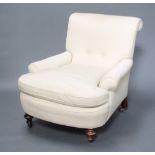 A Howard style armchair upholstered in white material, raised on turned supportsSome staining to the