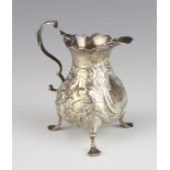 A Georgian silver pear shaped repousse cream jug with S scroll handle on pad feet 9cm, 78 grams