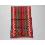 A blue, black and red ground Belouche rug with wavy design 132cm x 80cm