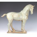 A stylish pottery figure of a standing horse raised on a rectangular platform, signed C S, 48cmThe
