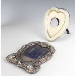 An Edwardian repousse silver heart shaped photograph frame, the border with Reynolds angels and