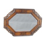 An Art Deco octagonal bevelled plate mirror contained in a carved and pierced oak frame 58cm h x