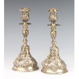 A pair of Portuguese repousse silver candlesticks 590 grams, 26cm There are minor dents to the