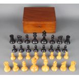 A turned wooden Staunton chess set Black queen has an old repair to crown and 2 small holes half way