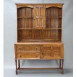 An Edwardian Art Nouveau oak dresser, the raised back with moulded cornice fitted a cupboard