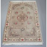 A mushroom ground and floral patterned Chinese carpet 282cm x 184cm Some staining to the carpet
