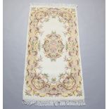 A white and floral patterned Indian rug 183cm h x 91cm w