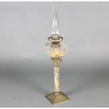 A Victorian faceted clear glass oil lamp reservoir raised on a gilt metal and marble effect column