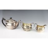 A 1930's silver melon shaped teapot, sugar bowl and milk jug with ebony mounts, London 1932, C S