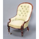 A Victorian mahogany show frame armchair upholstered in green buttoned material raised on turned