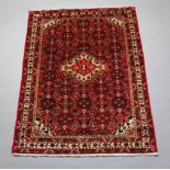 A red, white and blue floral patterned carpet with central medallion 201cm x 149cm