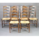 A set of 6 beech ladder back dining chairs with woven rush seats raised on turned supports