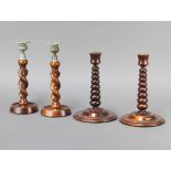 A pair of turned teak candlesticks formed from teak removed from HMS Britannia 23cm h x 15cm,