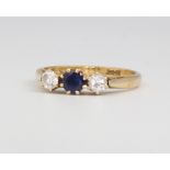 An 18ct yellow gold sapphire and diamond ring, the centre sapphire approx. 0.2ct flanked by diamonds