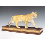 A Franklin Mint figure of a tiger - On The Prowl on a wooden stand 53cm