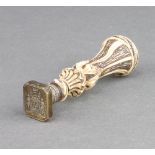 A Victorian metal seal with armorial decoration and carved bone stem 9cm x 1cm x 2cm