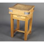 A square metal bound butcher's block raised on a beech stand with square supports and H framed