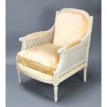 An Empire style white painted double cane bergere armchair, the seat and back upholstered in gold